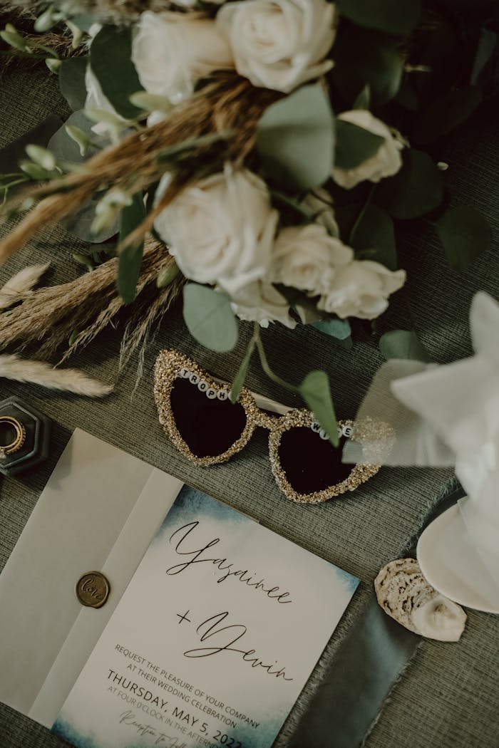 Chic wedding invitation flatlay with floral and decorative accents.